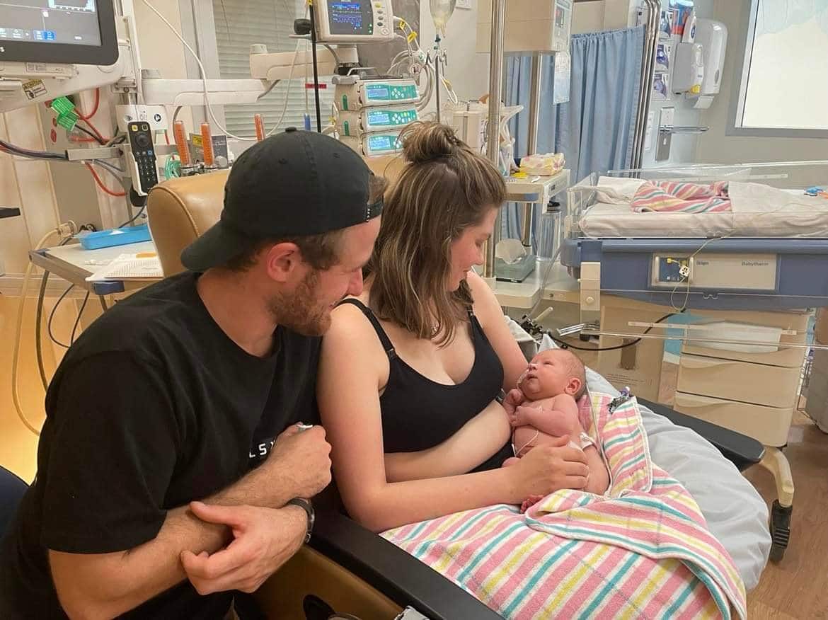 newborn baby in NICU being held by mother