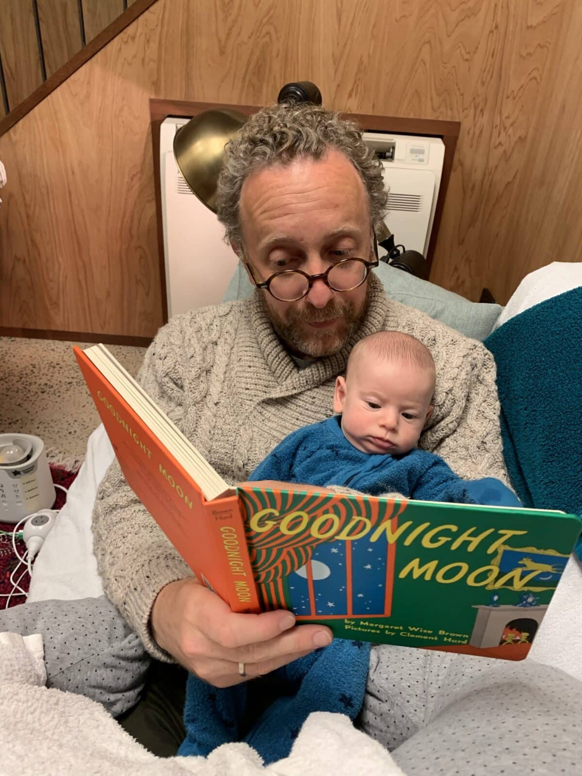 Australian father Dylan reading to his newborn